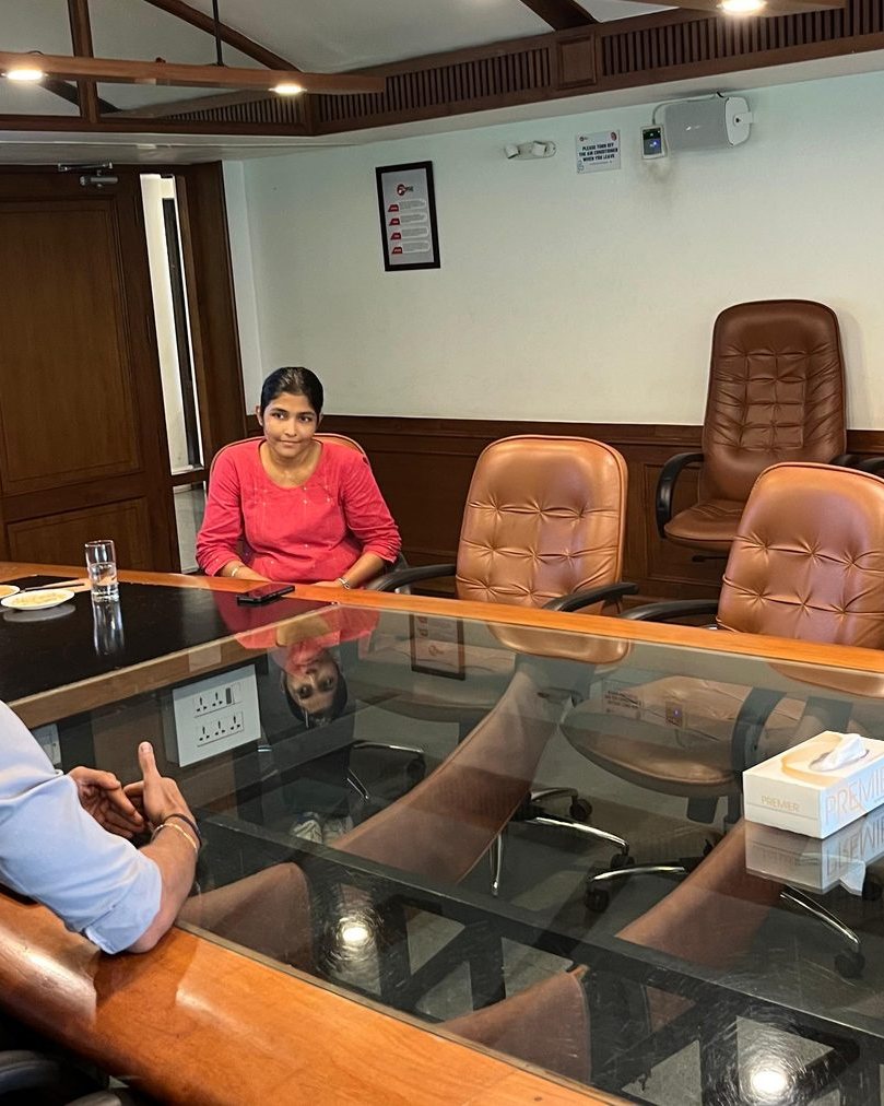 Two people in conversation across a boardroom table
